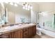 Bathroom featuring a double sink vanity, tile countertops and a shower-tub combination at 15146 W Highland Ave, Goodyear, AZ 85395