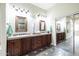 Bathroom featuring and sinks with wood cabinetry and decorative mirrors at 15146 W Highland Ave, Goodyear, AZ 85395