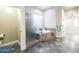 Bathroom featuring a tile floor, step-up soaking tub, and a glass shower enclosure at 15146 W Highland Ave, Goodyear, AZ 85395