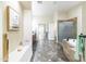 A bathroom featuring a soaking tub, tile flooring, and a separate shower room at 15146 W Highland Ave, Goodyear, AZ 85395