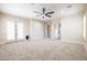 Large bedroom with ample space, neutral carpet, French doors, and a ceiling fan at 15146 W Highland Ave, Goodyear, AZ 85395