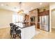 Spacious kitchen featuring a large center island with seating, stainless steel appliances, and stylish pendant lighting at 15146 W Highland Ave, Goodyear, AZ 85395