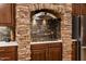 Close-up of a brick arch with cooktop, cabinets and stainless steel appliances at 15146 W Highland Ave, Goodyear, AZ 85395