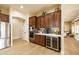 Stylish kitchen with stainless steel appliances, wood cabinets, built in wine fridge, and laminate floors at 15146 W Highland Ave, Goodyear, AZ 85395