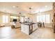 Spacious kitchen island with black countertop and sink, seamlessly connecting to the living and dining areas at 15146 W Highland Ave, Goodyear, AZ 85395