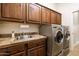 Laundry room featuring a tile counter, utility sink, and modern washer and dryer units at 15146 W Highland Ave, Goodyear, AZ 85395