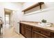 Spacious laundry room featuring wooden cabinetry and a laminate wood floor at 15146 W Highland Ave, Goodyear, AZ 85395