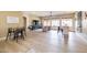 Well-lit living room showcasing laminate floors, neutral decor, bar seating and large picture windows at 15146 W Highland Ave, Goodyear, AZ 85395