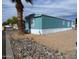 Charming mobile home with blue siding, a palm tree in the front, and stone landscaping at 15625 N 25Th St # 21, Phoenix, AZ 85032