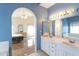 Bathroom with double sink vanity, archway to bedroom, and bright blue walls at 15644 S 13Th Pl, Phoenix, AZ 85048