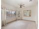 Bright living room with large windows, a ceiling fan, neutral carpet, and a decorative mirror at 15644 S 13Th Pl, Phoenix, AZ 85048