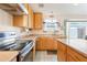 Kitchen featuring wood cabinets, stainless steel appliances, and tile flooring at 1619 E Silverbirch Ave, Buckeye, AZ 85326