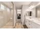 Elegant bathroom features a double vanity, stylish fixtures, and a glass shower, with a walk-in closet at 16278 W Jenan Dr, Surprise, AZ 85379