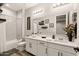 A clean bathroom features a dual sink vanity with tiled backsplash, white cabinetry and shower-tub combo at 16278 W Jenan Dr, Surprise, AZ 85379