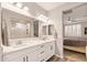 Bright bathroom features double sinks, white cabinets, modern fixtures, and a glass-enclosed shower; seamlessly connects to bedroom at 16278 W Jenan Dr, Surprise, AZ 85379