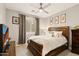 A cozy bedroom featuring a wooden sleigh bed, neutral walls, and large window with shutter style blinds at 16278 W Jenan Dr, Surprise, AZ 85379