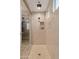 Walk-in shower with neutral tiling, multiple shower heads, built-in shelving, and a glass enclosure for a spa-like experience at 16278 W Jenan Dr, Surprise, AZ 85379