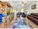 Spacious living room featuring tile floors, a ceiling fan, leather furniture, and a custom entertainment center at 17542 W Pinnacle Vista Dr, Surprise, AZ 85387