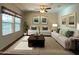 Living room with large windows, neutral-toned furniture, decorative pillows, and a patterned rug at 17542 W Pinnacle Vista Dr, Surprise, AZ 85387