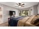 Comfortable bedroom featuring a ceiling fan, large window, and neutral color scheme at 17634 W Hearn Rd, Surprise, AZ 85388