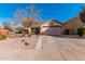 Charming single-story home featuring a two-car garage and desert landscaping with cacti and drought-tolerant plants at 17634 W Hearn Rd, Surprise, AZ 85388