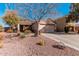 Charming single-story home featuring a two-car garage and desert landscaping with cacti and drought-tolerant plants at 17634 W Hearn Rd, Surprise, AZ 85388