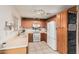 Well-lit kitchen with wooden cabinets, white appliances, and a chalkboard feature at 17634 W Hearn Rd, Surprise, AZ 85388