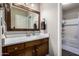 Bathroom with a wood vanity, large mirror, and bath/shower combo at 1825 W Ray Rd # 2116, Chandler, AZ 85224