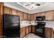 Classic kitchen featuring oak cabinets, modern black appliances, and neutral countertops at 1825 W Ray Rd # 2116, Chandler, AZ 85224