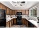 Classic kitchen featuring oak cabinets, modern black appliances, and neutral countertops at 1825 W Ray Rd # 2116, Chandler, AZ 85224