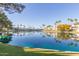 Scenic view of a tranquil pond reflecting the surrounding lush greenery and community buildings under a blue sky at 1825 W Ray Rd # 2116, Chandler, AZ 85224