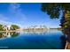 Calm community pond reflects palm trees and surrounding residences under a bright, clear blue sky at 1825 W Ray Rd # 2116, Chandler, AZ 85224