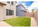 Backyard showing green grass and rock landscaping against the house and block wall at 19075 E Pelican Dr, Queen Creek, AZ 85142