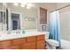 Bright bathroom featuring a wood vanity, large mirror, and a bathtub with a blue shower curtain at 19075 E Pelican Dr, Queen Creek, AZ 85142