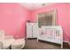 Pink bedroom featuring a crib, chair, and dresser at 19075 E Pelican Dr, Queen Creek, AZ 85142