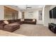 Cozy living room featuring plush carpeting, a ceiling fan and a large sectional sofa at 19075 E Pelican Dr, Queen Creek, AZ 85142