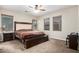 Carpeted main bedroom featuring a large bed and three windows at 19075 E Pelican Dr, Queen Creek, AZ 85142