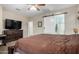 Main bedroom featuring a barn door to bathroom and TV at 19075 E Pelican Dr, Queen Creek, AZ 85142