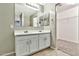 Bathroom features double sinks, white cabinets, large mirror and adjacent closet at 2210 E Caspian Way, San Tan Valley, AZ 85140