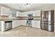 Bright kitchen with stainless steel appliances, white cabinets, and tile flooring at 2210 E Caspian Way, San Tan Valley, AZ 85140