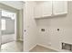 Bright laundry room with tile flooring and white cabinets for storage at 2210 E Caspian Way, San Tan Valley, AZ 85140