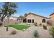 Private backyard oasis with artificial turf, desert landscaping, and a covered patio for outdoor enjoyment at 2416 E Cielo Grande Ave, Phoenix, AZ 85024