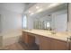 Bright bathroom featuring a large mirror, double vanity, tub, and a separate shower area at 2416 E Cielo Grande Ave, Phoenix, AZ 85024