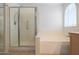 Bright bathroom with a shower stall, a soaking tub and a window with plantation shutters at 2416 E Cielo Grande Ave, Phoenix, AZ 85024