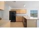 Functional kitchen with wood cabinetry and modern black appliances at 2416 E Cielo Grande Ave, Phoenix, AZ 85024