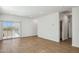 Bright living room featuring wood-look tile flooring and sliding glass door access at 25401 W Sunland Ave, Buckeye, AZ 85326