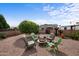 Landscaped backyard with gravel, mature trees, and seating around a stone fire pit for outdoor entertaining at 2568 N Armour Ave, Mesa, AZ 85215