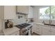 Well-appointed kitchen with white cabinetry, modern appliances, and stylish herringbone backsplash at 2902 E Pierson St, Phoenix, AZ 85016