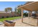 Relaxing backyard with a covered patio, a well-maintained lawn, and a modern fire pit feature at 3023 E John Cabot Dr, Phoenix, AZ 85032