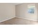 This bedroom features neutral walls and carpet, and has a large window to let in light at 3025 W Night Owl Ln, Phoenix, AZ 85085